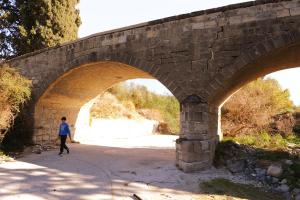 a person running under a stone bridge at Esperando in Maroni