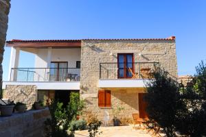 een stenen huis met rode deuren en een balkon bij Esperando in Maroni