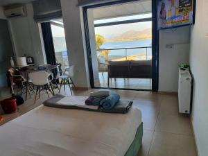 a bedroom with a bed with a view of the ocean at Anny's studio in Chalkida