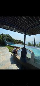 a person sitting under an umbrella next to a swimming pool at Star House in Xiaoliuqiu