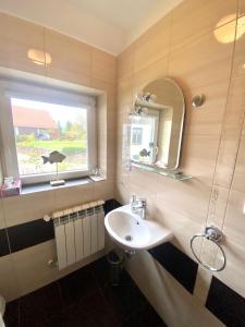 un bagno con lavandino e finestra di Haus Masur a Mikołajki Altre 91 foto