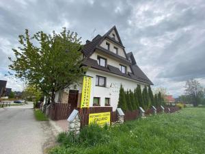 a large white house with a sign in front of it at Willa Pod Kotelnicą in Białka Tatrzańska