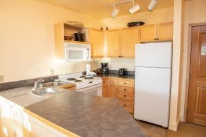 uma cozinha com um frigorífico branco e um lavatório em 8309 Silver Mill condo em Keystone