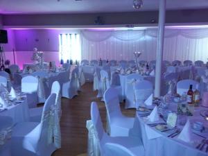 una sala banchetti con tavoli e sedie bianchi di The Davron Hotel a Fraserburgh