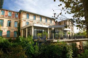 a large building with a bridge in front of it at Résidence de Tourisme Vacances Bleues Villa Regina in Arcachon