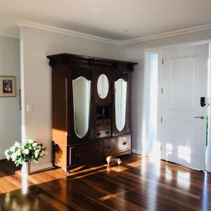 a large wooden dresser with two mirrors in a room at Jetty Splendour Guest Bedroom with Bathroom en-suite B'nB in Coffs Harbour