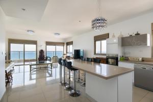 a kitchen with a counter and a table with chairs at Voice of The Sea in Acre