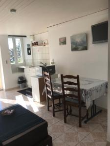- une cuisine avec une table et des chaises dans la chambre dans l'établissement Charmant Studio meublé, à Montignac-Charente