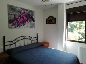 een slaapkamer met een blauw bed en een raam bij Puerto Lorente in Cazorla