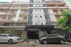 two cars parked in front of a building at OYO 935 The Palm Apartment in Bangkok