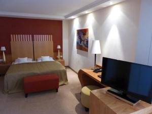 a hotel room with a bed and a flat screen tv at Hotel Roshop in Barnstorf