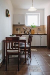 cocina con mesa, sillas y fregadero en Magas-lak Apartman Eger, en Eger