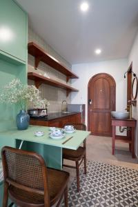 une cuisine avec une table, deux chaises et un comptoir dans l'établissement JooHouse Lux, à Hô-Chi-Minh-Ville