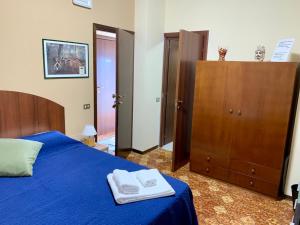 a bedroom with a blue bed and a wooden cabinet at b&b Casa di Antonio_Etna Vacanze in Trecastagni