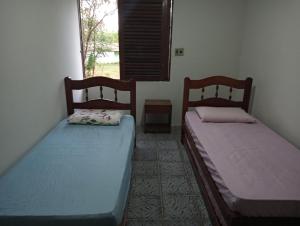 two beds sitting in a room with a window at Recanto a ver o Mar in Sirinhaém