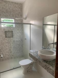 een badkamer met een wastafel, een toilet en een douche bij Casa com piscina em c vermelha in Porto Seguro