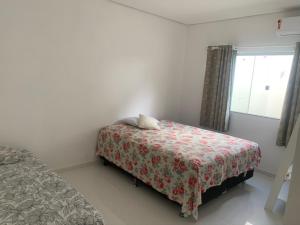 a small bedroom with a bed and a window at Casa com piscina em c vermelha in Porto Seguro