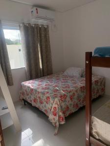 a small bedroom with a bed and a window at Casa com piscina em c vermelha in Porto Seguro