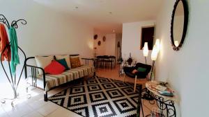 a living room with a couch and a mirror at Happy Terrace Downtown Tiny House 100% Portuguese in Faro