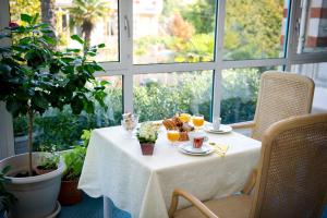 a table with a plate of food and glasses of orange juice at Résidence de Tourisme Vacances Bleues Villa Regina in Arcachon