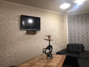 sala de estar con sofá y TV en la pared en Rayskiy Sad, en Volytsya