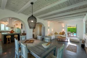 a dining room and living room with a table and a kitchen at Villa Perla Blanca in Platánion