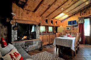 sala de estar con mesa y chimenea en Aparthotel Foyer d'antan SUITE con caminetto hammam o vasca idromassaggio, en Brusson