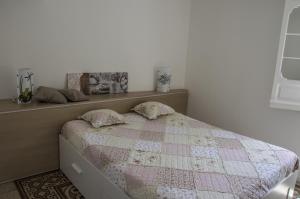 a bedroom with a bed with a quilt on it at Parva Domus Intera casa indipendente in centro in Modica