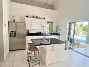 a kitchen with white cabinets and a stainless steel refrigerator at Villa Koko Jan Thiel in Jan Thiel