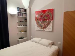 una camera da letto con un letto e un dipinto sul muro di Very Central suite apartment with 1bedroom next to the underground train station Monaco and 6min from casino place a Monte Carlo