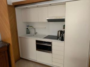 a kitchen with white cabinets and a sink at Very Central suite apartment with 1bedroom next to train station Monaco and 6min from casino place in Monte Carlo