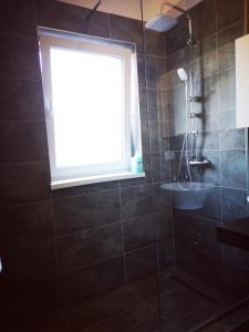 een badkamer met een raam en een douche bij Vivamus Studio in Braşov