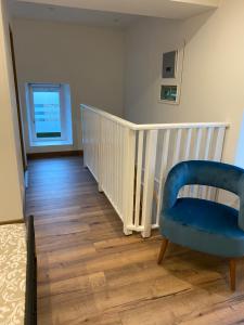 une chambre avec une chaise bleue et un escalier dans l'établissement cottage Philippe et Valérie, à Silli-en-Gouffern