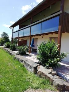 un edificio con ventanas de cristal y arbustos delante de él en Ferienwohnung 4 in den Krautgärten, en Ochsenburg