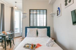 Apartments WS Louvre - Richelieu في باريس: غرفة نوم بها سرير عليه صينية طعام