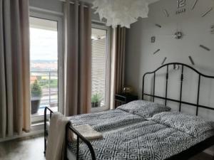a bedroom with a bed with a clock on the wall at Apartament przy Aquaparku w Redzie in Rumia