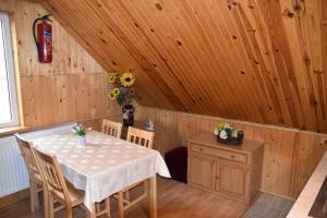 - une salle à manger avec une table et des chaises dans une cabine dans l'établissement Domek Jaskółka, à Białowieża