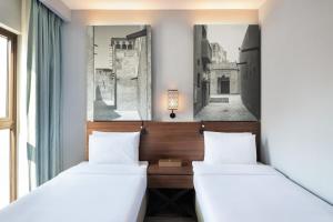 two beds in a room with a window at ibis Styles Dubai Gold District in Dubai +72 photos