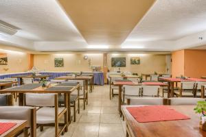 a dining room with wooden tables and chairs at Rasa Hotel in Búzios