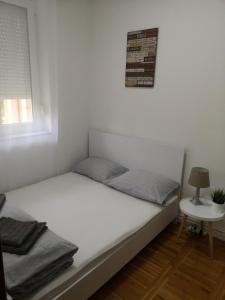 a small bedroom with a bed and a table at Smiley 2 - Subotica Centar in Subotica