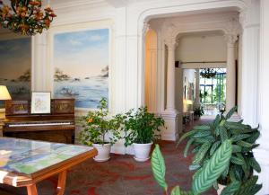 a room with potted plants and a piano at Résidence de Tourisme Vacances Bleues Villa Regina in Arcachon
