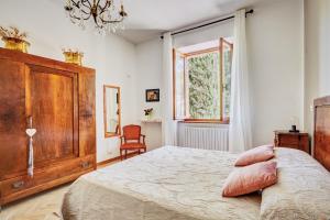 sypialnia z łóżkiem, komodą i oknem w obiekcie Casa Bonari w mieście Monticchiello