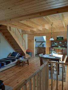 a log cabin with a bed and a dining room at Na Łąkie in Szczecinek