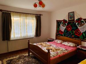 - une chambre avec un lit et une couette rouge dans l'établissement Pensiunea Anca, à Rona de Jos