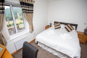 a bedroom with a white bed and a window at The Windmill Inn in Watchet