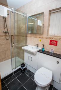 a bathroom with a shower and a toilet and a sink at The Windmill Inn in Watchet