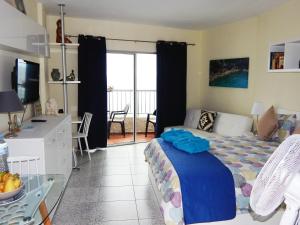 Dormitorio con cama, escritorio y TV en Apartamento Monis Natura en Icod de los Vinos