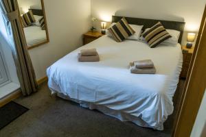 a bedroom with a large white bed with two pillows at The Windmill Inn in Watchet