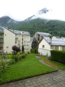 un cortile con edifici e una montagna sullo sfondo di A la montagne à 2 App107 a Cauterets
