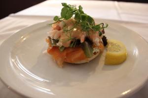 a white plate with a piece of fish and a lemon at The Windmill Inn in Watchet